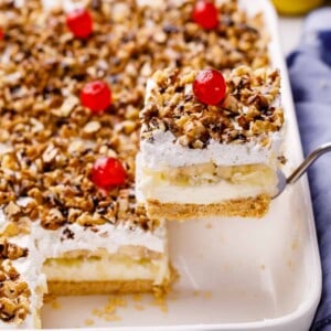 A slice of banana split cake being lifted from a pan.