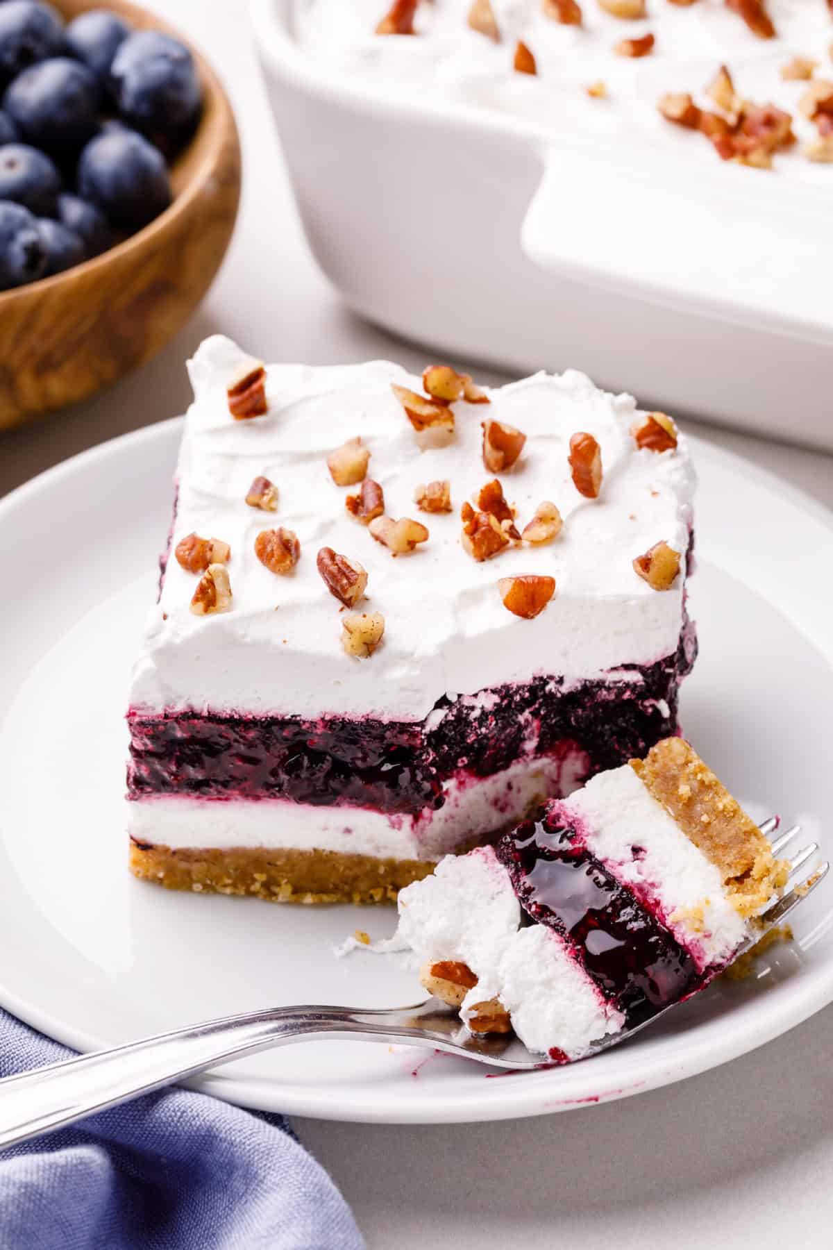 blueberry delight with a forkful of the dessert serve on a white plate