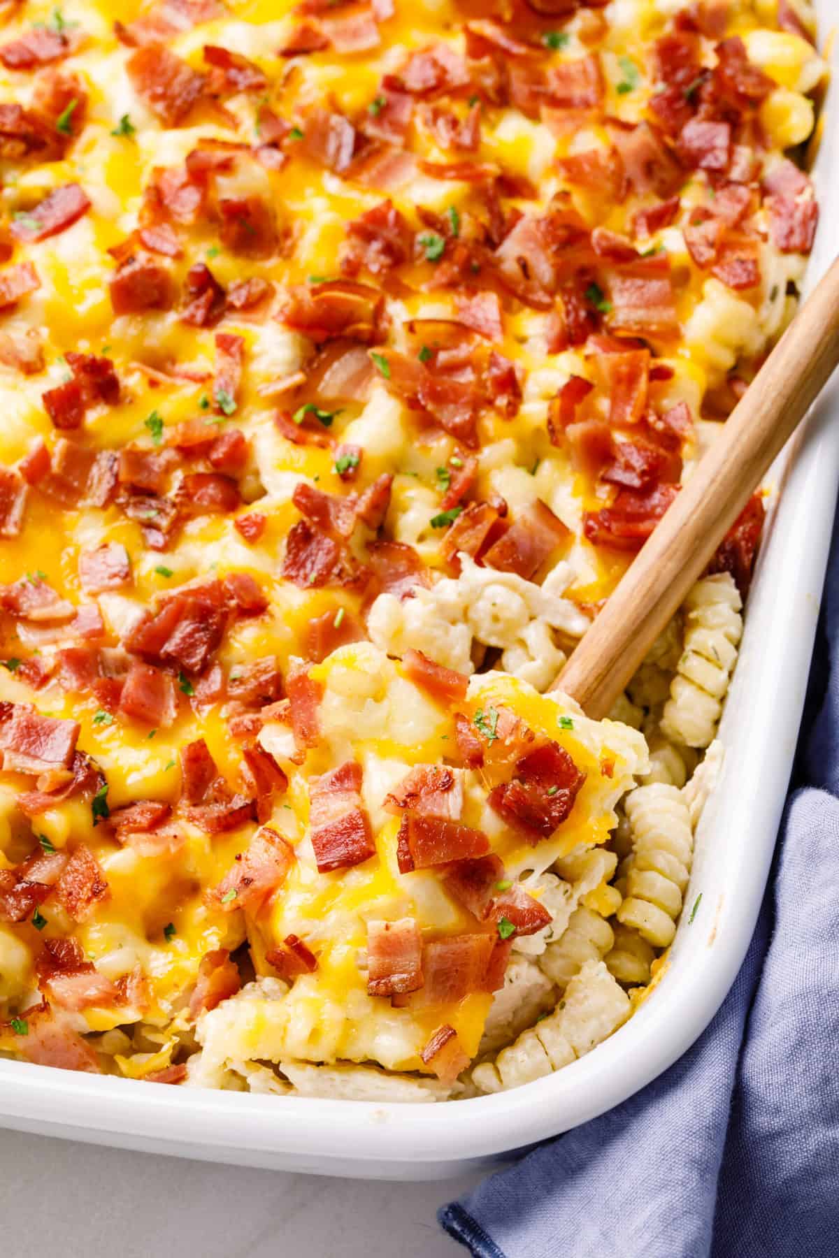 Chicken Bacon Ranch Casserole in a baking dish with a wooden spoon