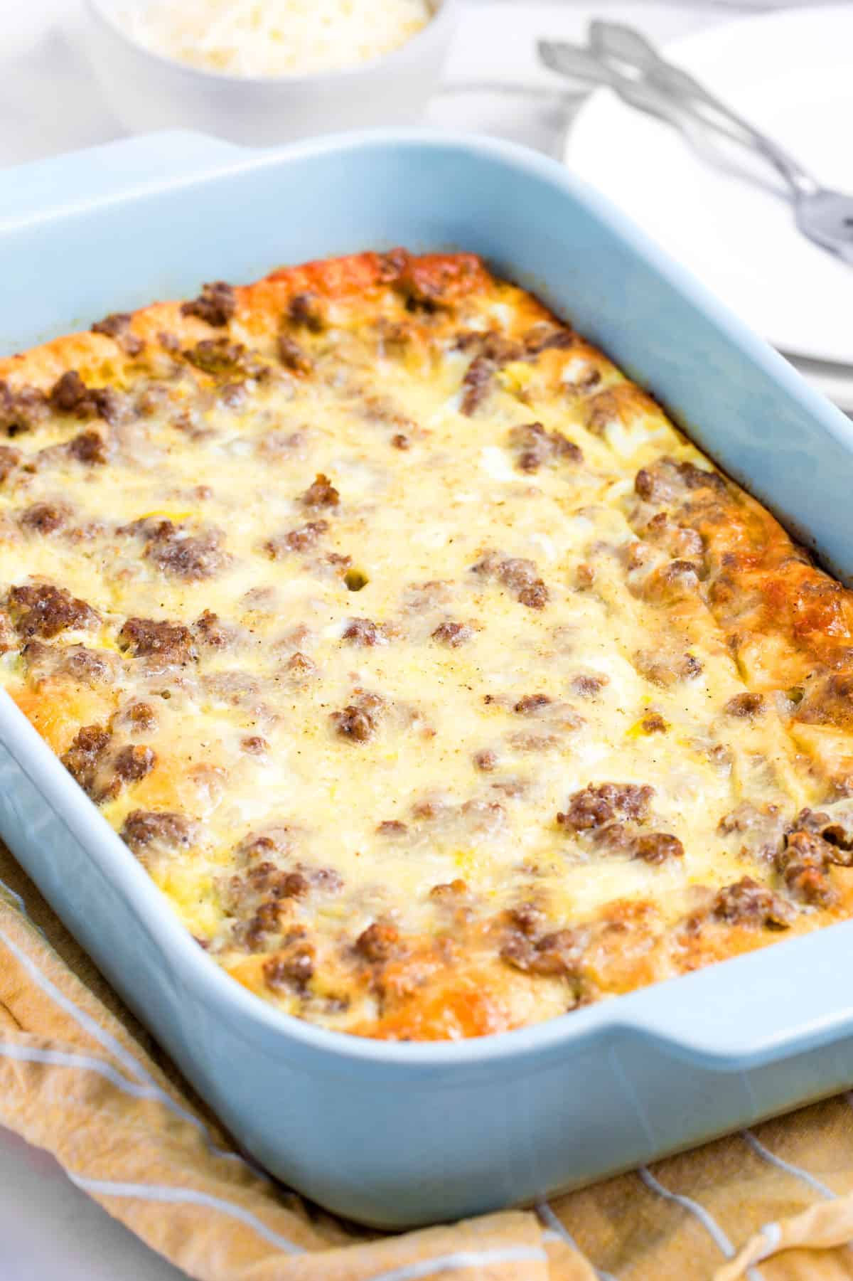 crescent roll breakfast casserole served in a blue casserole dish.