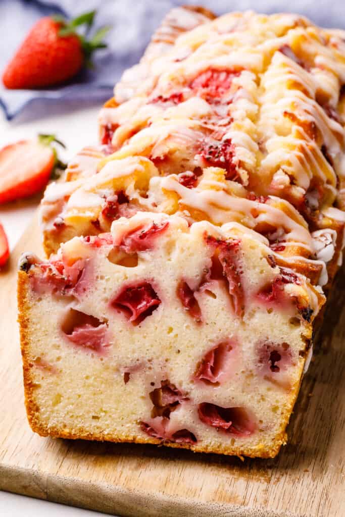 a loaf of strawberry bread on a cutting board