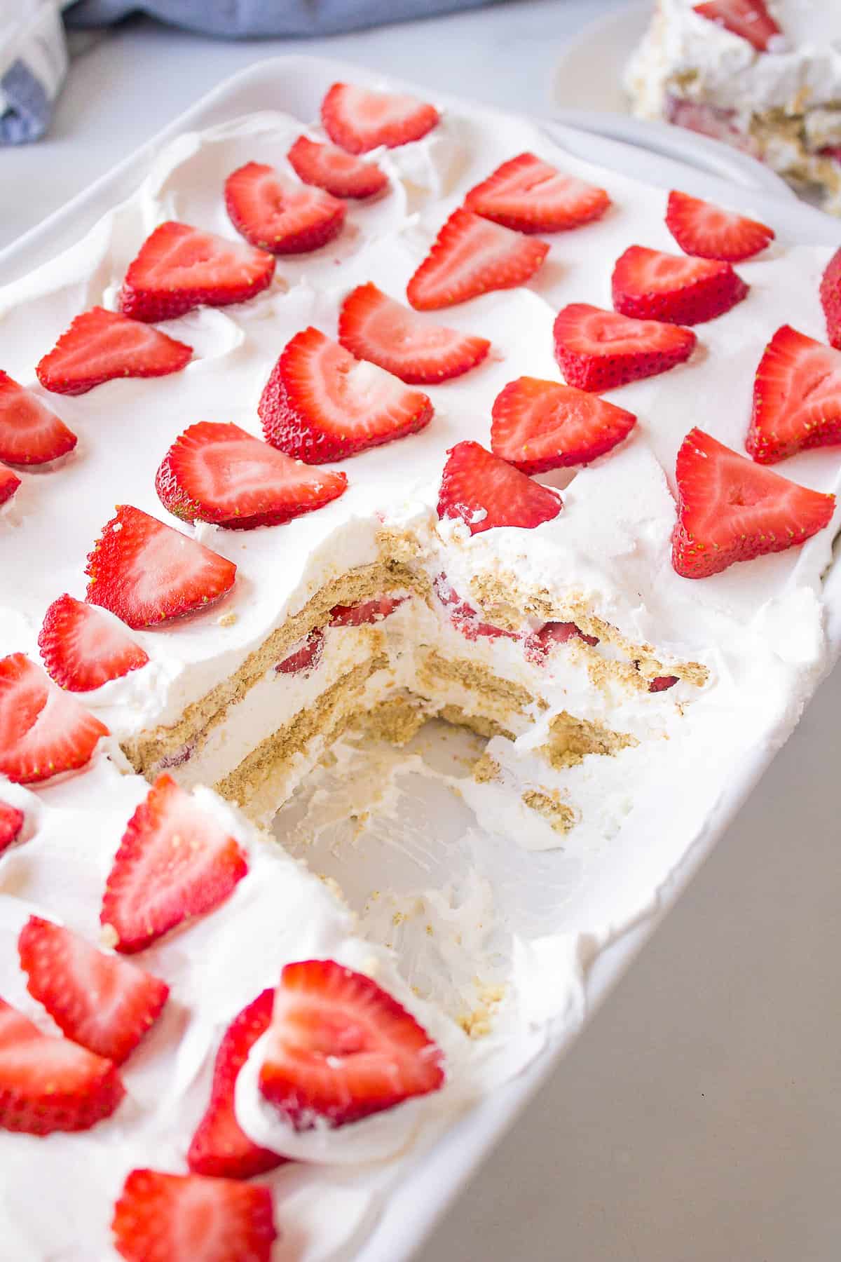 close up image of strawberry icebox cake served in a casserole dish showing the cross section