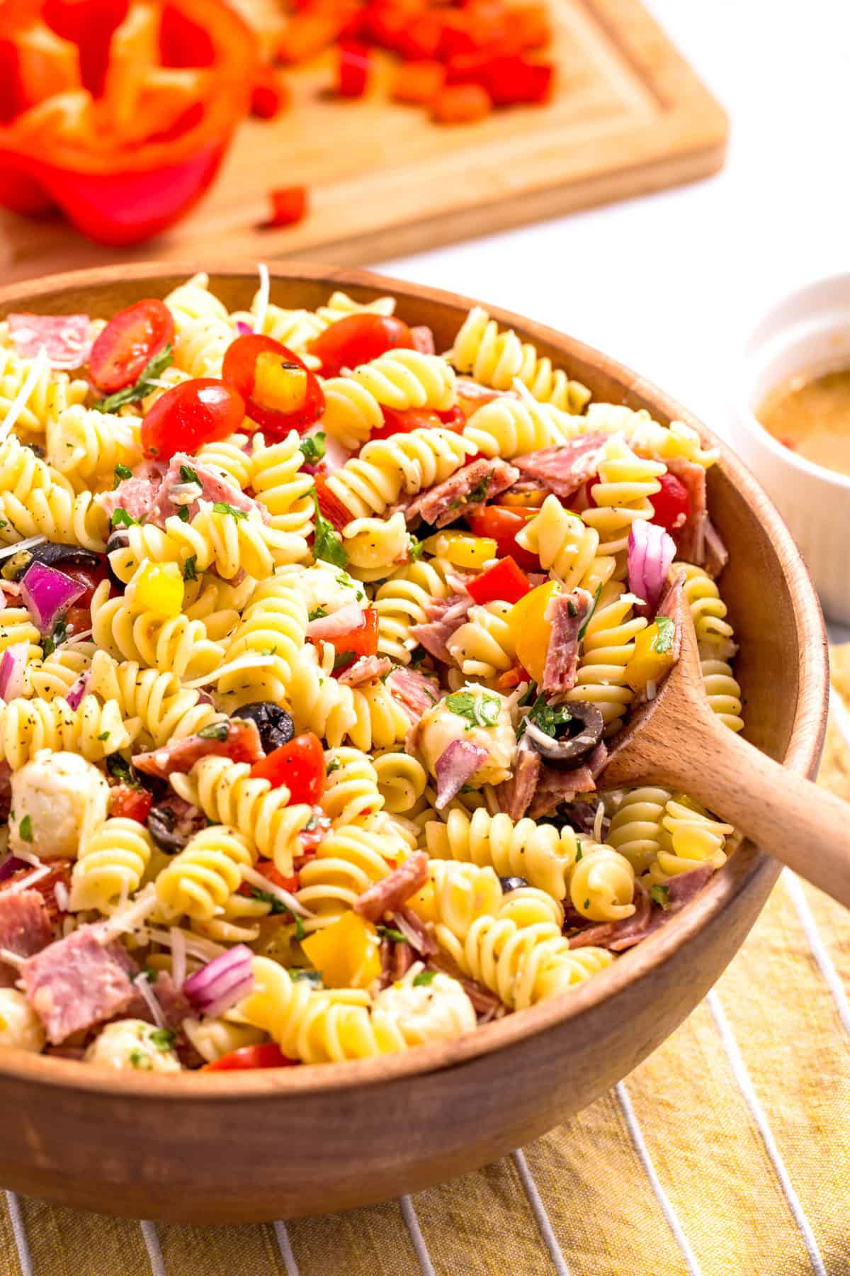 wooden bowl of italian pasta salad with a wooden spoon