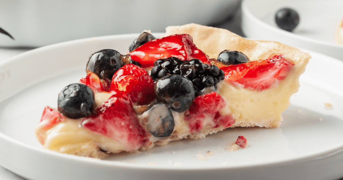 A slice of fruit tart on a plate. 