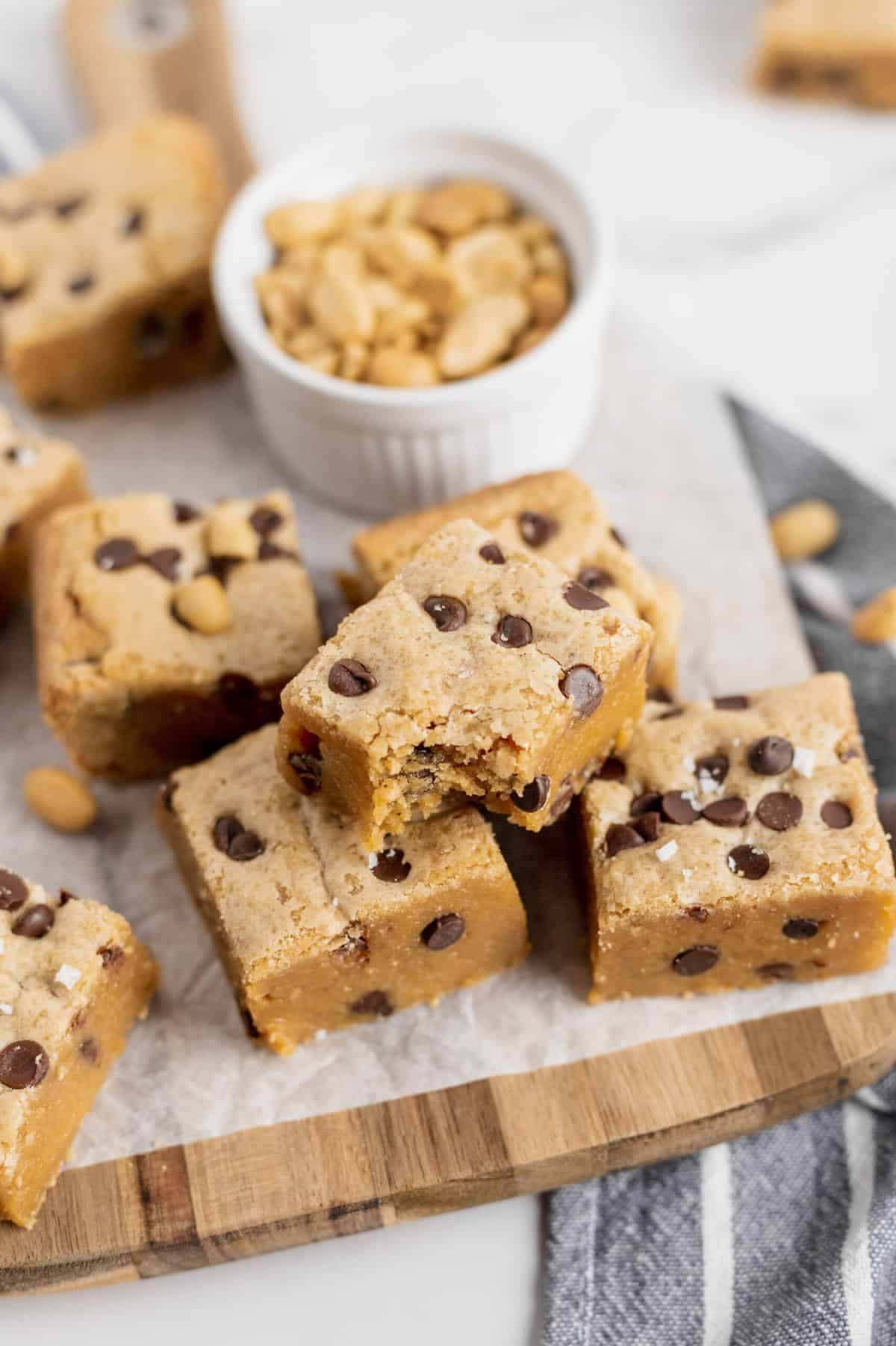 stack of chocolate chip peanut butter blondies on a wooden board