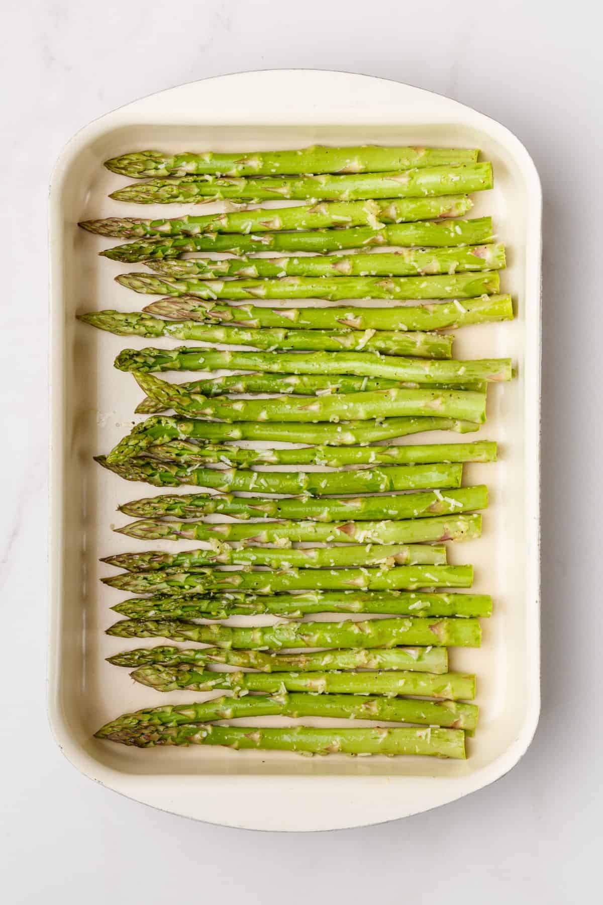 top down image of prepped asparagus sitting on a baking tray. 