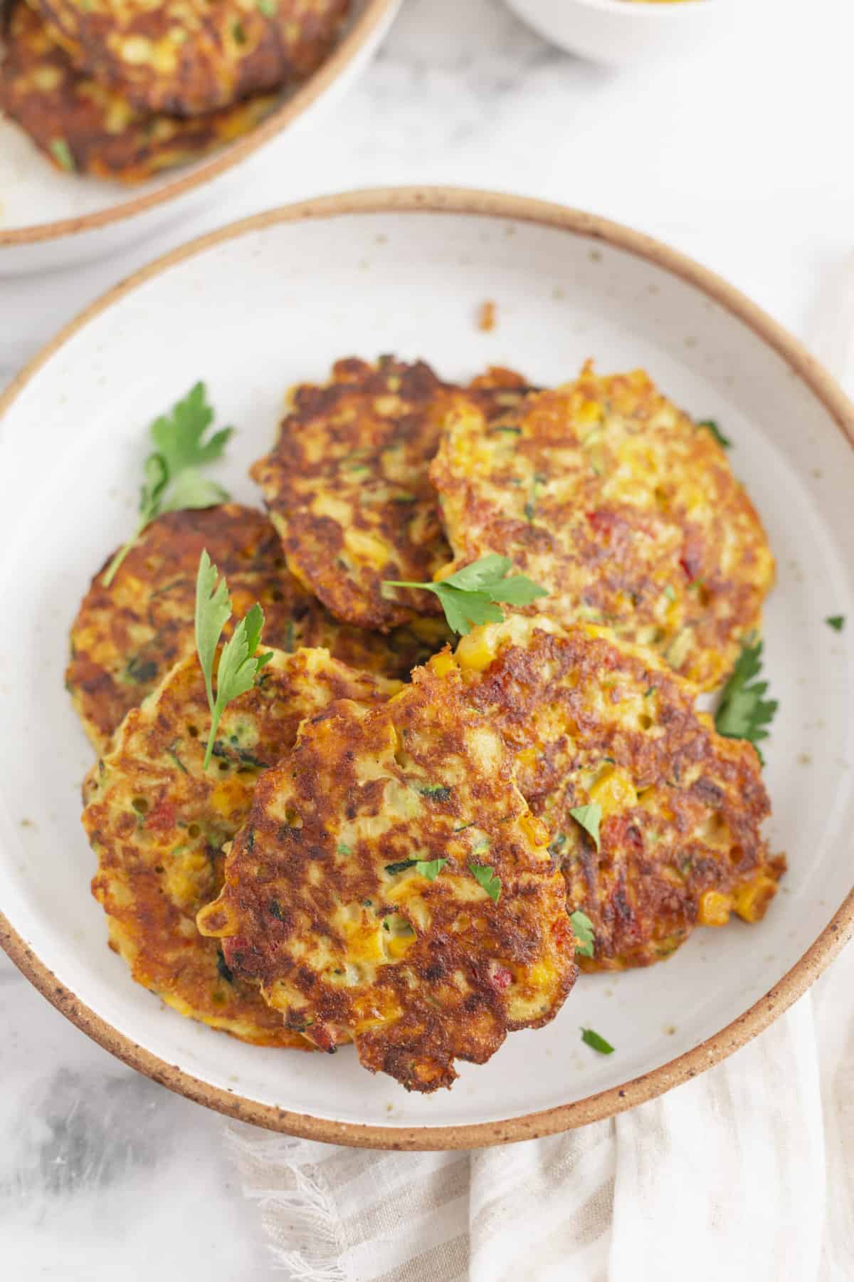 plate of zucchini corn fritters garnished with parsley
