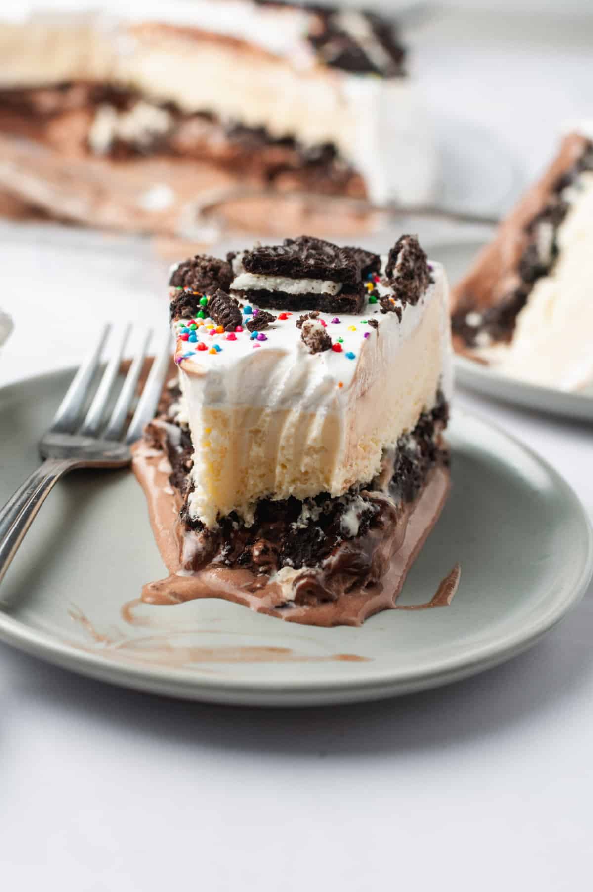 cross section image of a slice of copycat dairy queen ice cream cake served on a grey round plate.