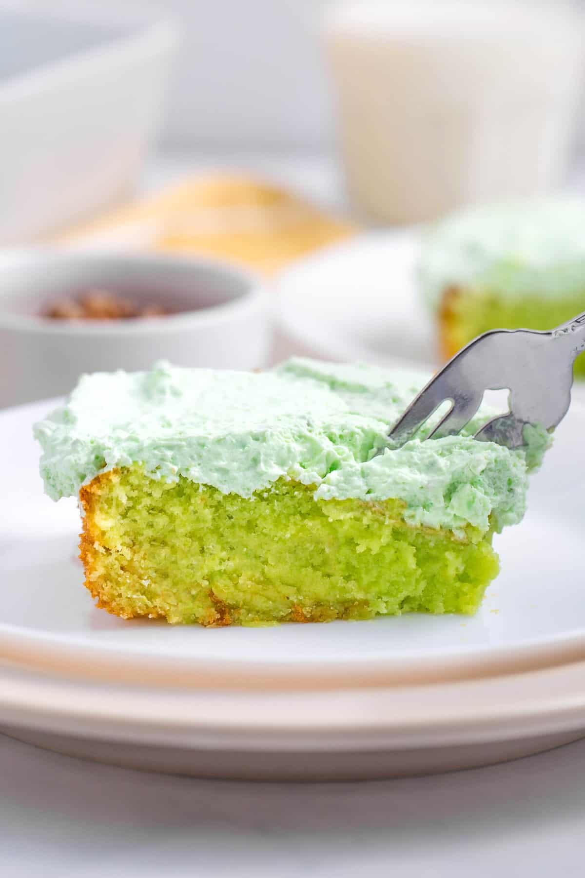 fork digging into a serving of pistachio cake