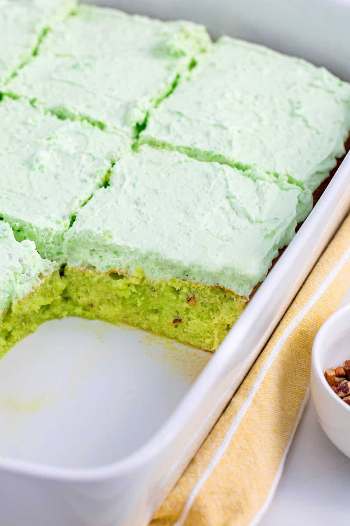 close up of pistachio cake showing cross section served in a baking dish