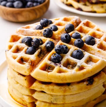 stack of waffles topped with fresh blueberries