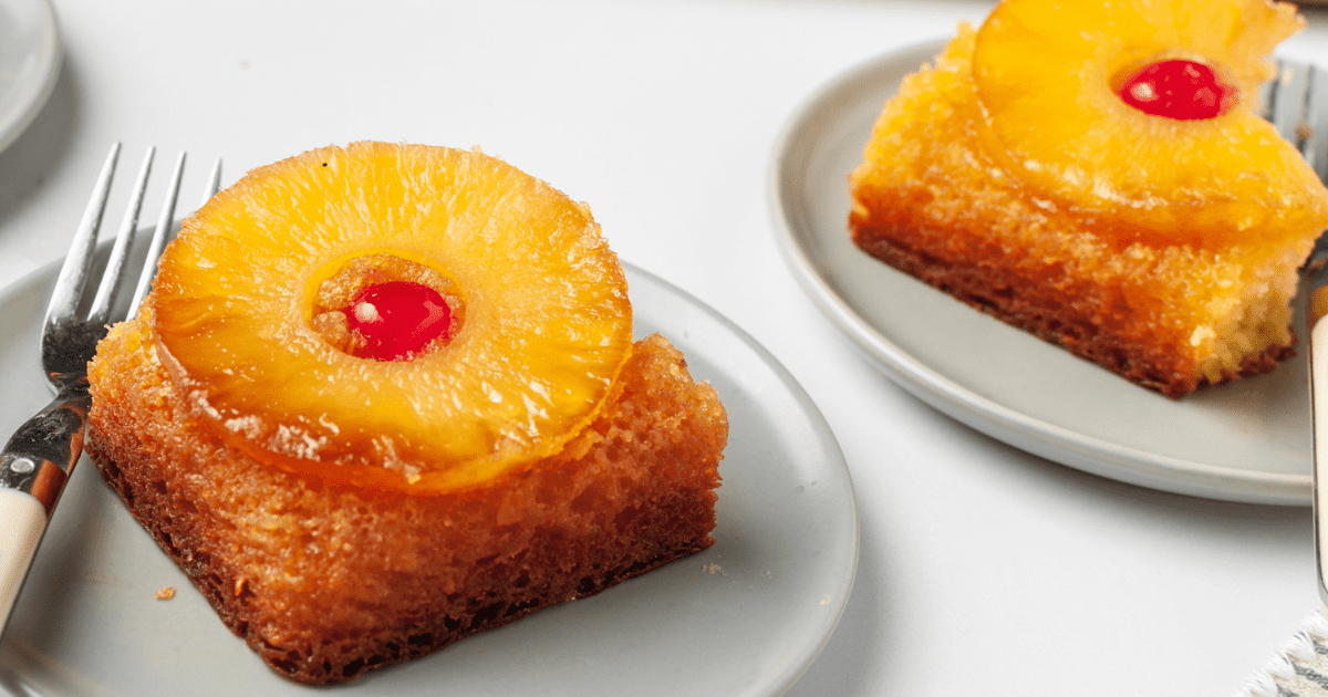 Two slices of pineapple upside down cake on plates. 