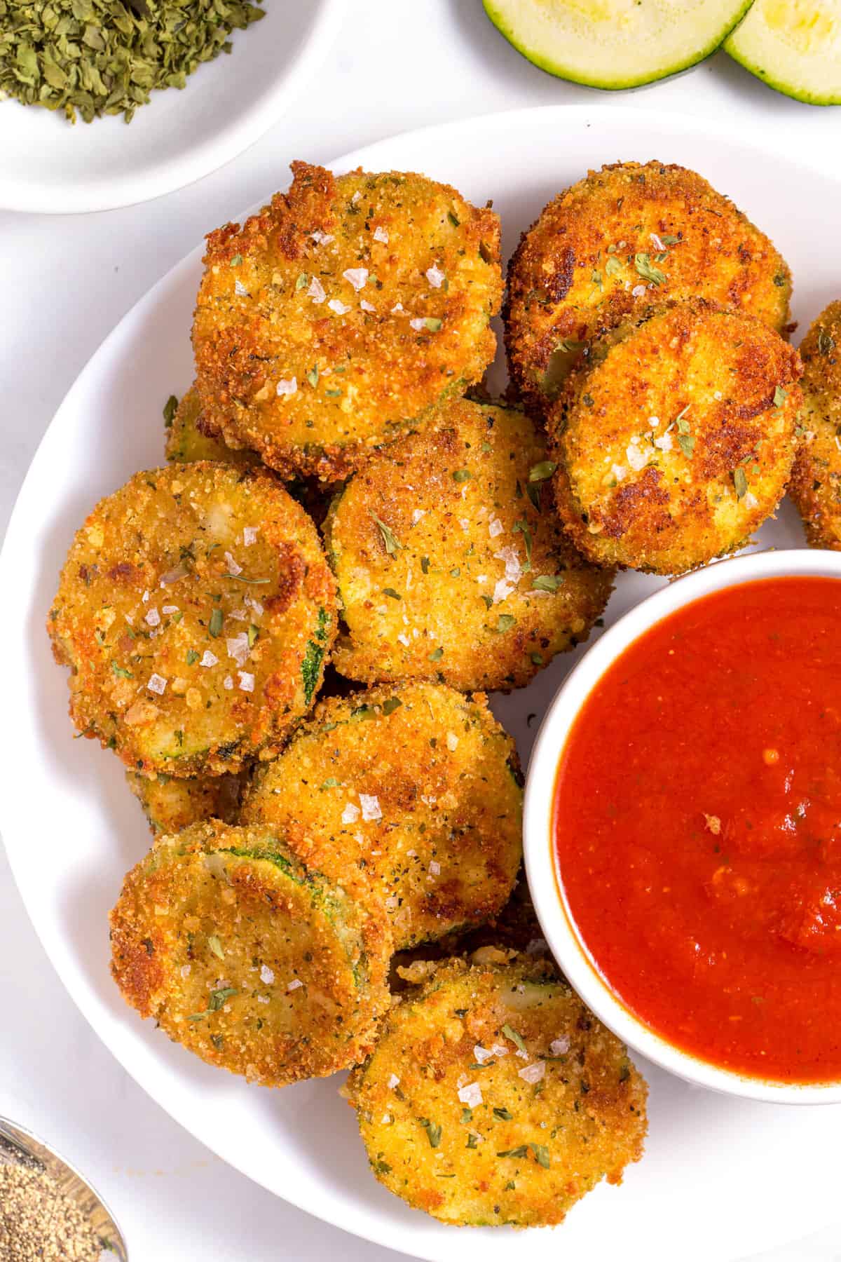 top down close up image of fried zucchini served with a side of marinara sauce