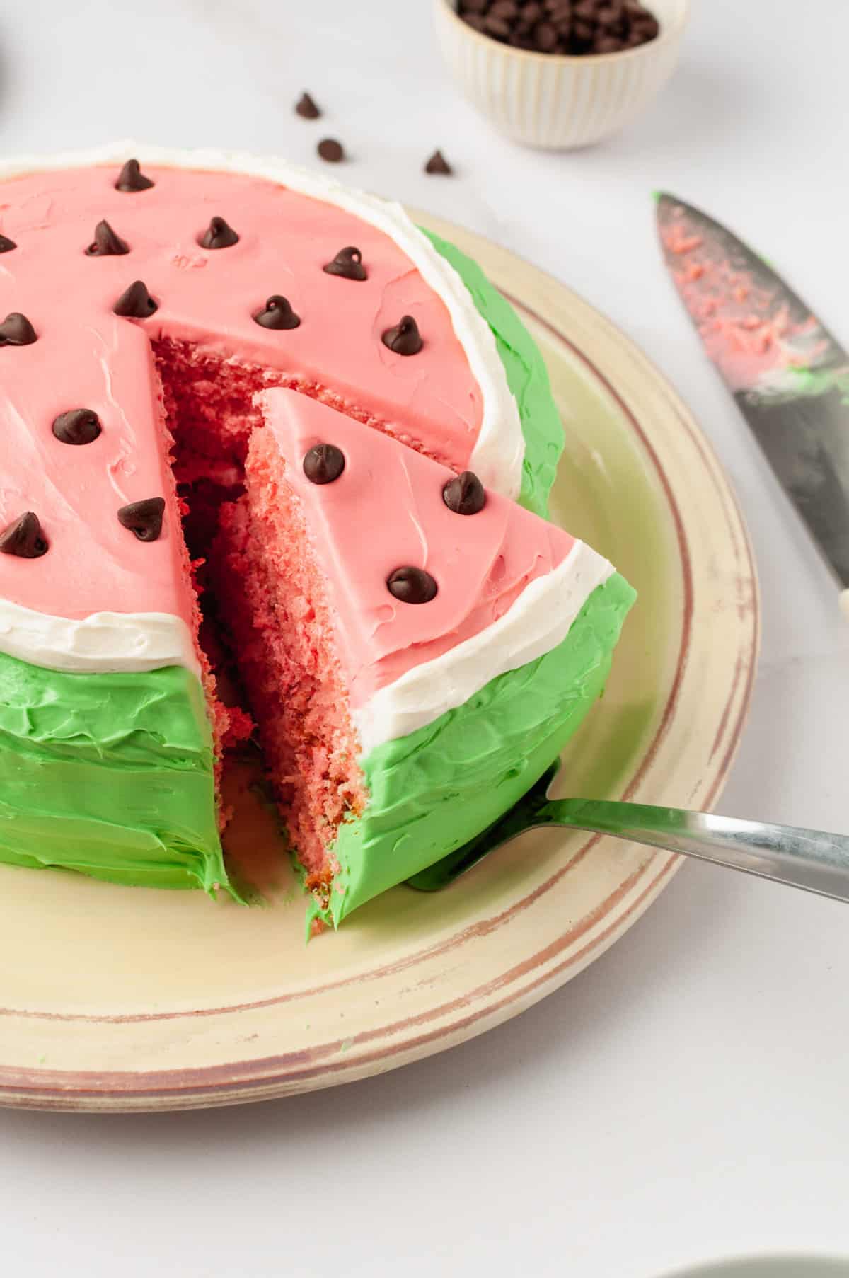 slice of watermelon cake being taken out with a cake spatula