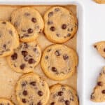 Crispy chewy chocolate chip cookies on a baking sheet.