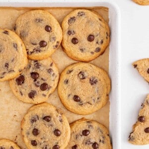 Crispy chewy chocolate chip cookies on a baking sheet.