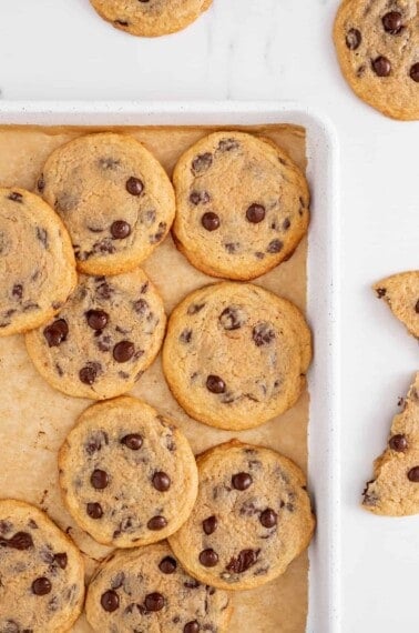 Crispy chewy chocolate chip cookies on a baking sheet.