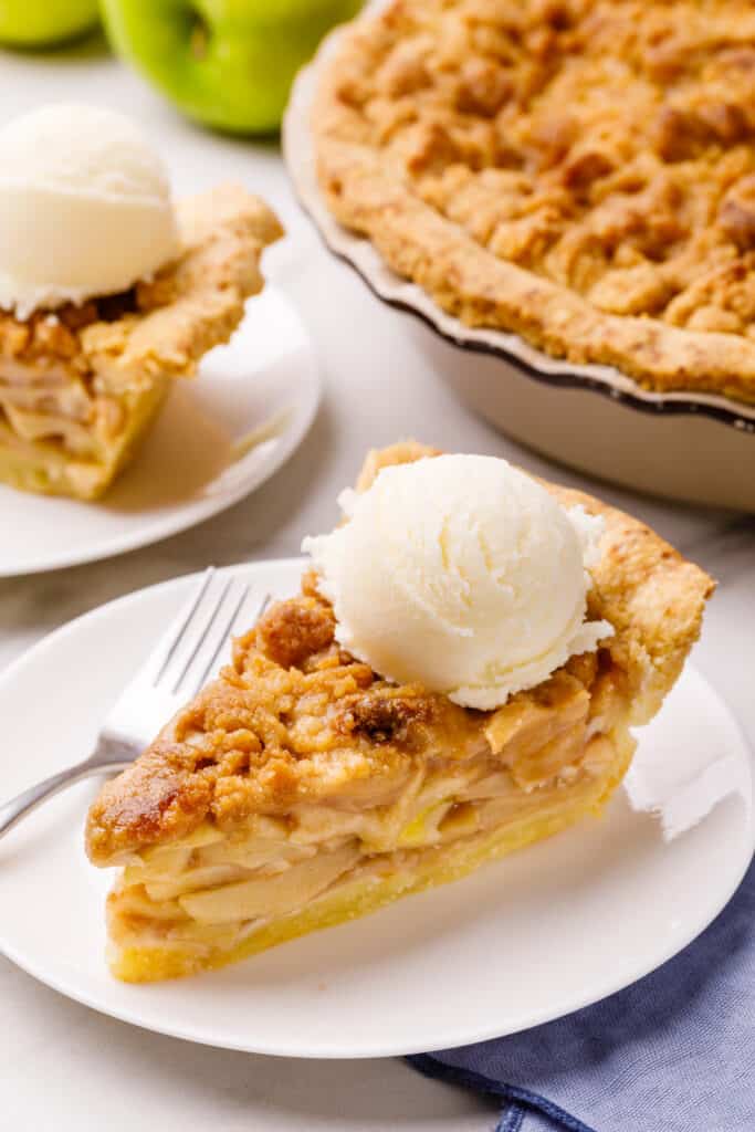 A slice of Dutch apple pie topped with ice cream.