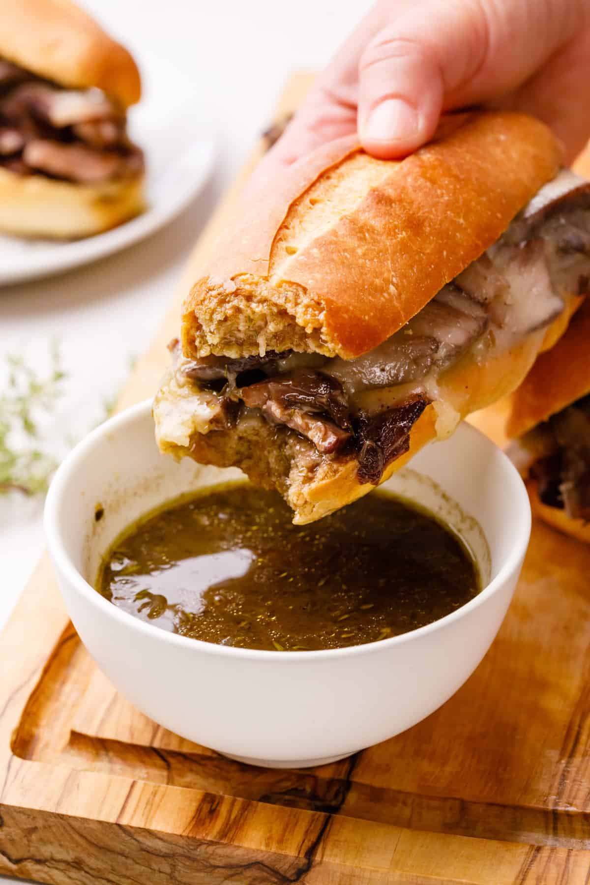 bite into a french dip sandwich and dipped in jus