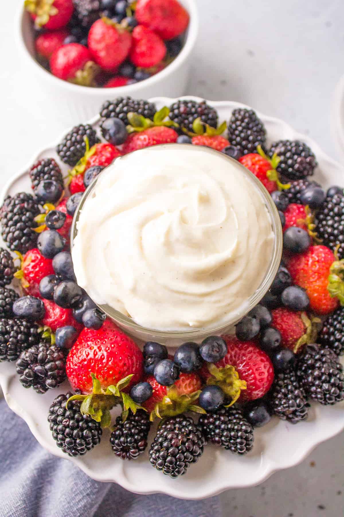 bowl of fruit dip served with a side of mixed berries