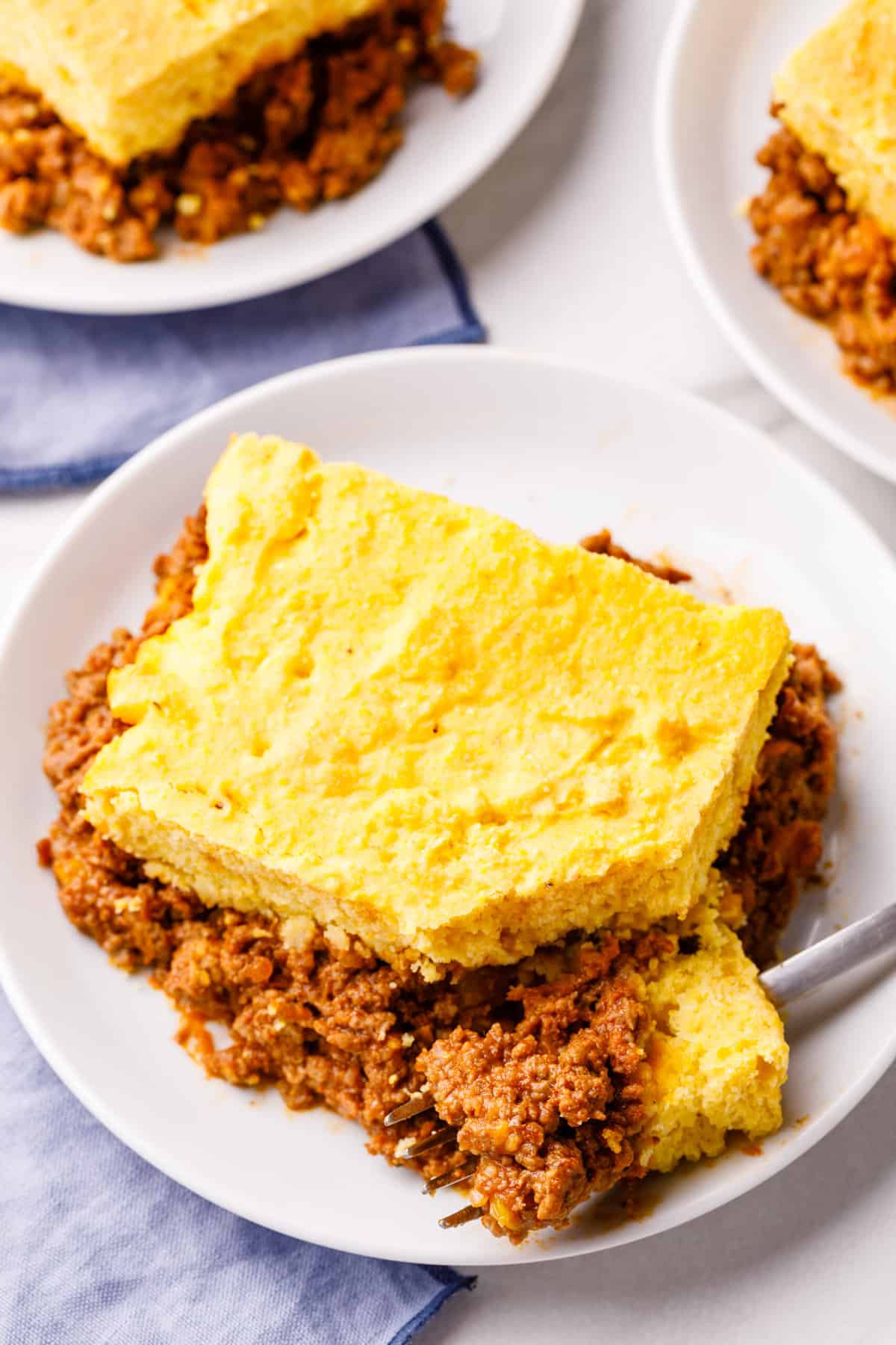 serving of sloppy joe casserole on a white plate with a forkful of casserole