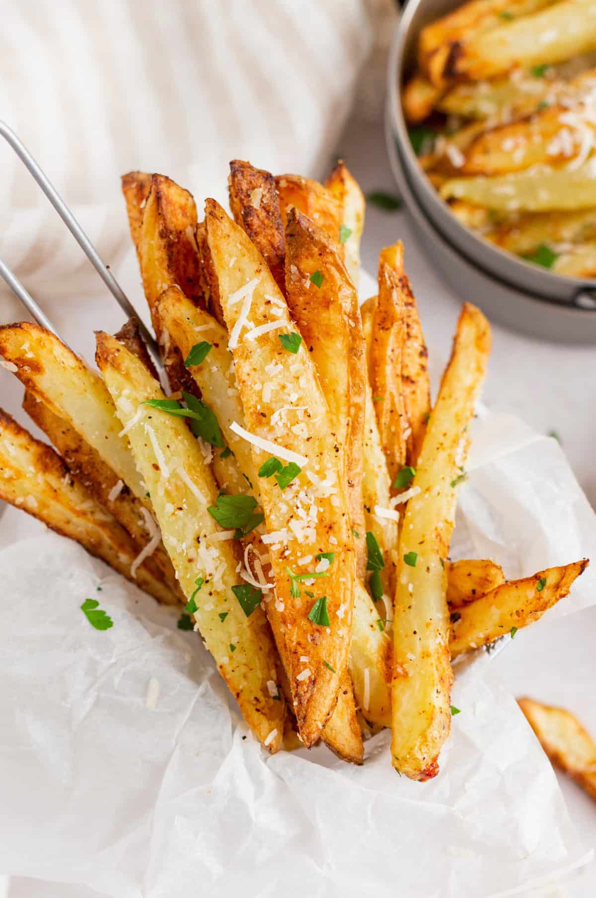 Close-up image of air fryer, Parmesan fries served in a basket.