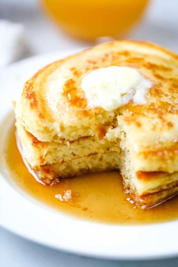 fluffy pancakes on a white plate with syrup. 