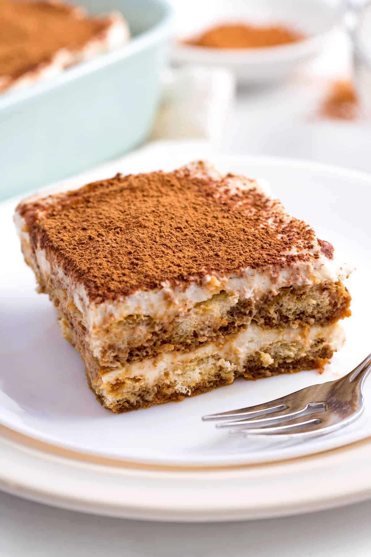 square serving of tiramisu cake served on a white plate