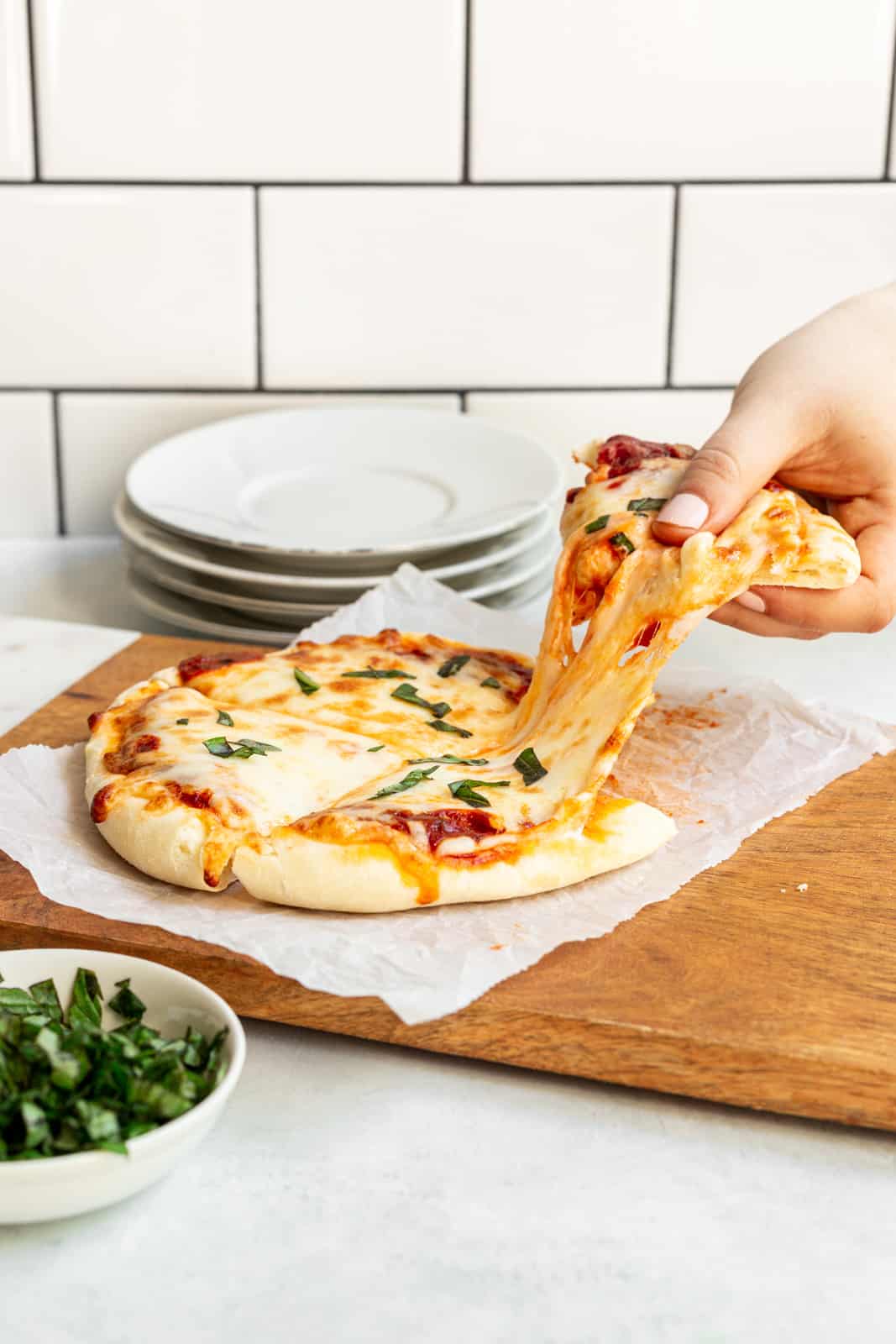 hand pulling apart pizza slice showing a cheese pull