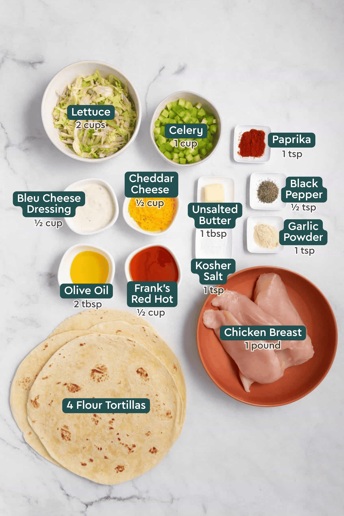 Ingredients for buffalo chicken wraps, including lettuce, celery, seasonings, blue cheese dressing, cheddar, oil, hot sauce, chicken, tortillas.