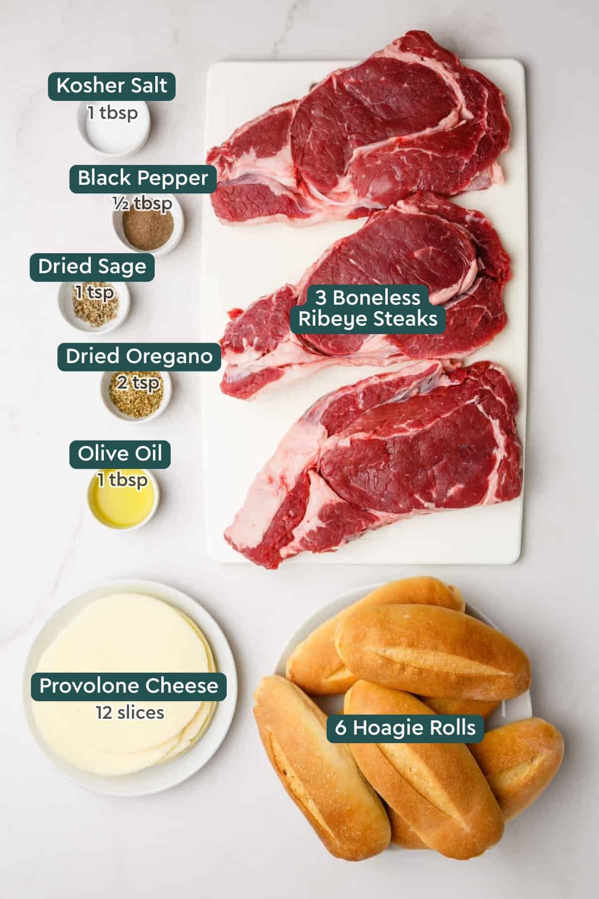 Ingredients for French dip sandwich including steaks, seasonings, oil, hoagie rolls, and cheese.