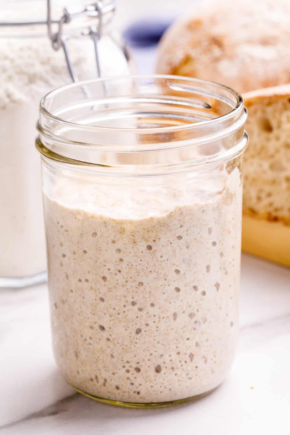 close up image of sourdough starter in a glass jar