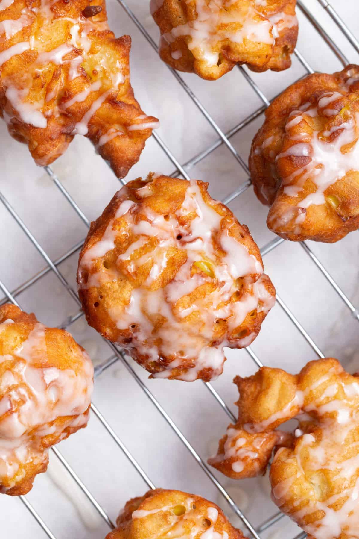 top down view of apple fritters on a wire cooling rack