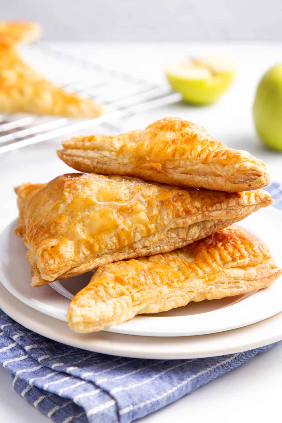 stack of three apple turnovers served on a white round plate
