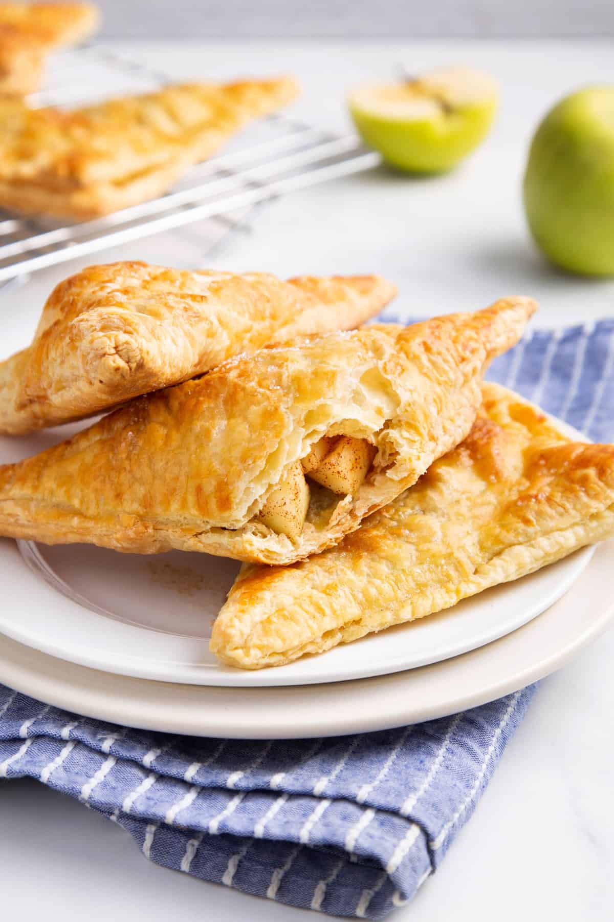 stack of three apple turnovers on a white plate