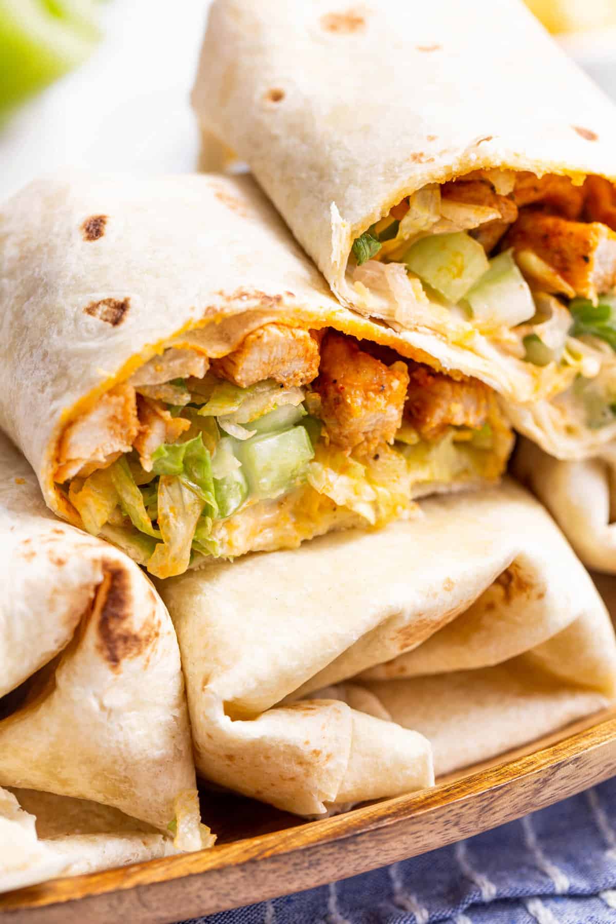 close up image of the cross section of buffalo chicken wraps stacked on other wraps