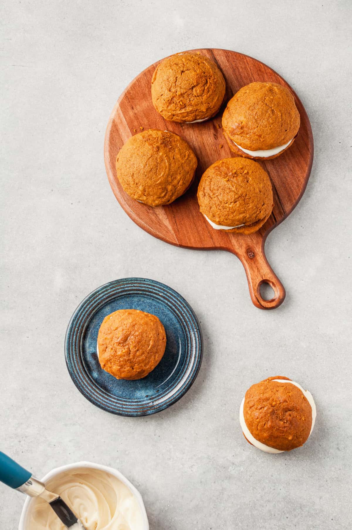 top down image of pumpkin whoopie pies served on a dark blue plate or wooden board with a handle or directly on the countertop
