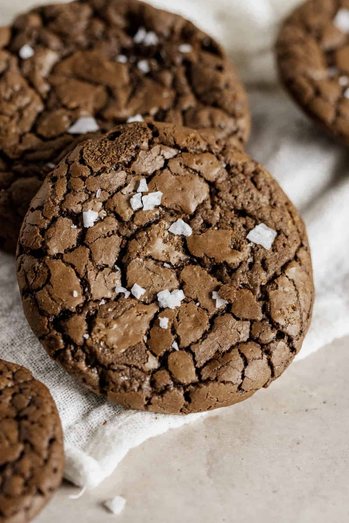 close up of a brownie chocolate chip crinkle cookie topped with sea salt