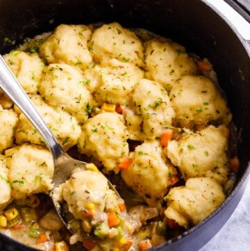Easy chicken & dumplings in a pot being lifted with a spoon.