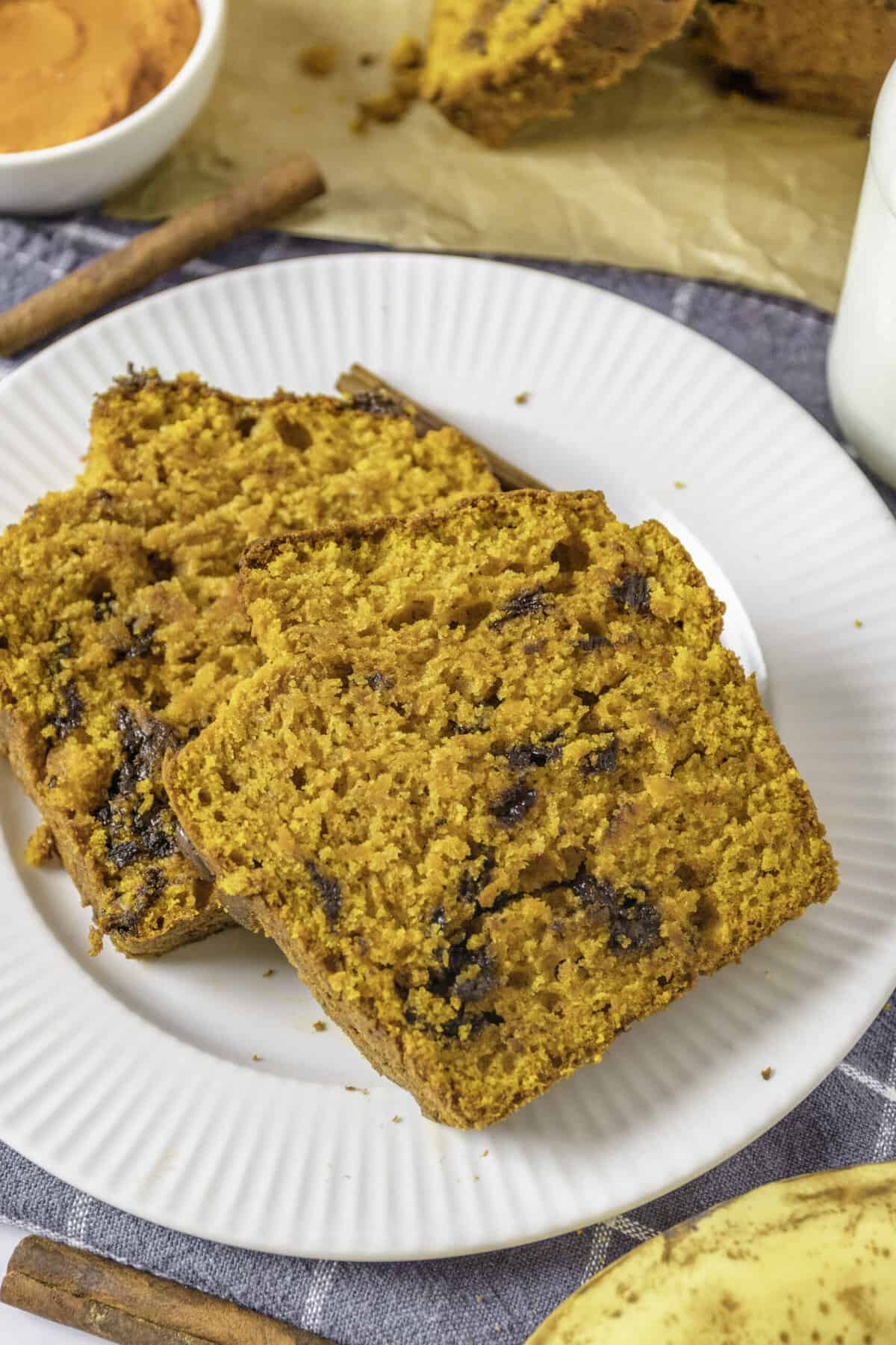 three slices of pumpkin banana bread served on a white round plate