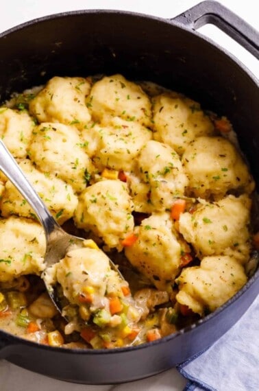 Easy chicken & dumplings in a pot being lifted with a spoon.