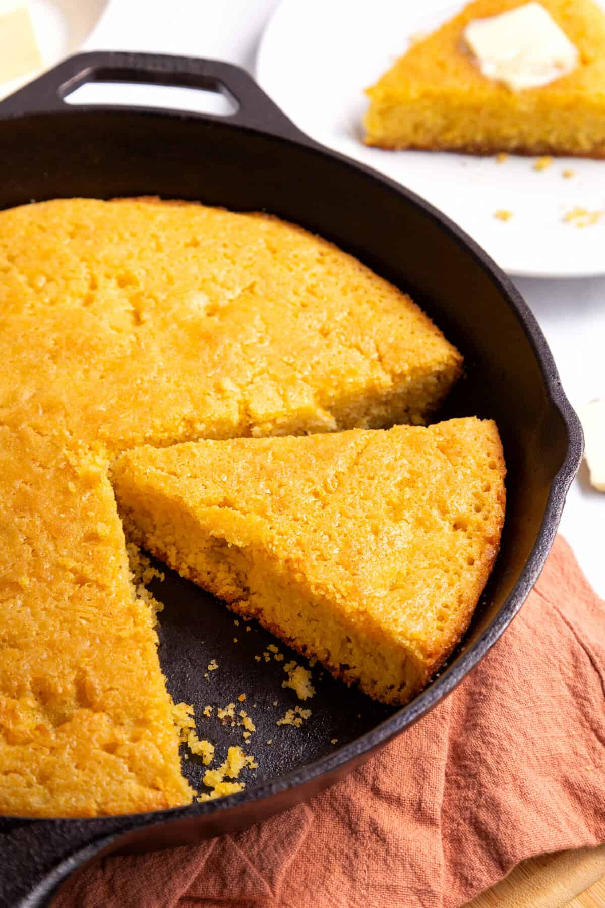 close up image of skillet cornbread served in a cast iron skillet