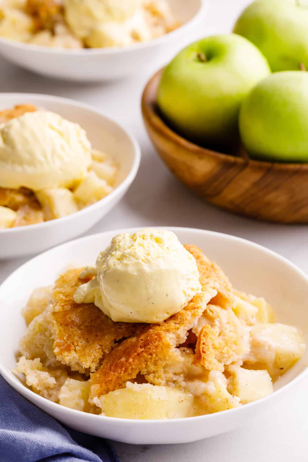 bowl of apple cobbler with a scoop of vanilla ice cream