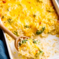 Cheesy broccoli rice casserole in a baking dish with servings missing.