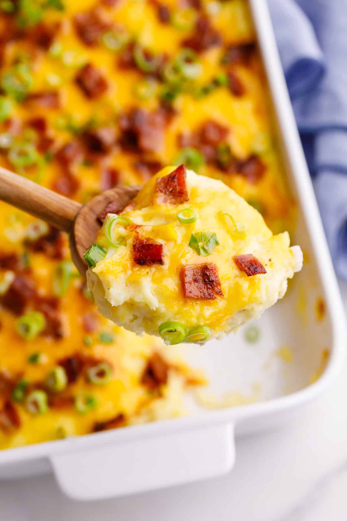 close up image of make ahead mashed potato casserole on a wooden spoon