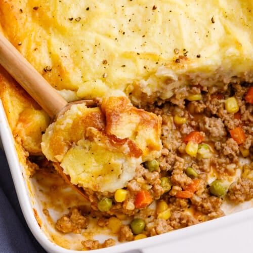 A baking dish full of shepherd's pie with servings missing.