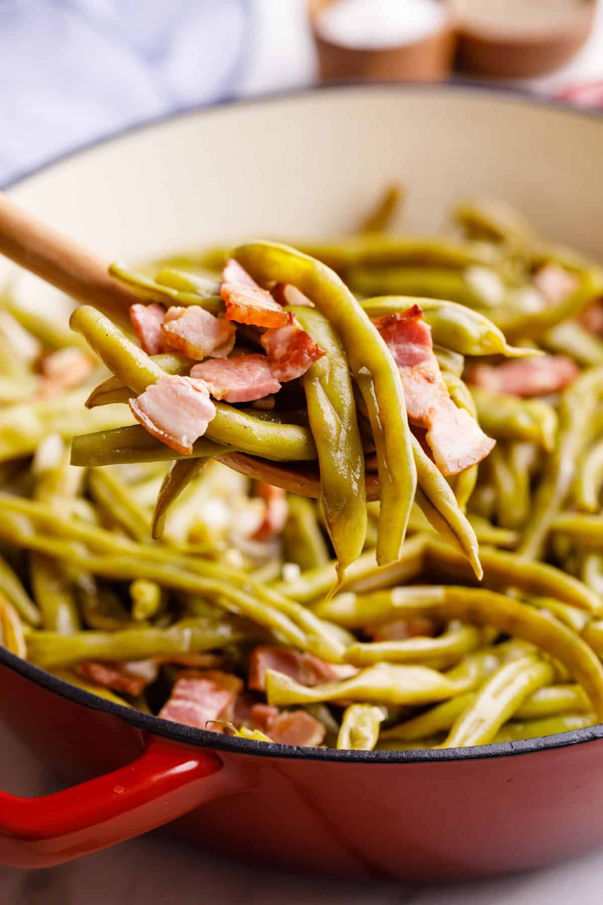 close up image of southern style green beans sitting on a wooden spoon