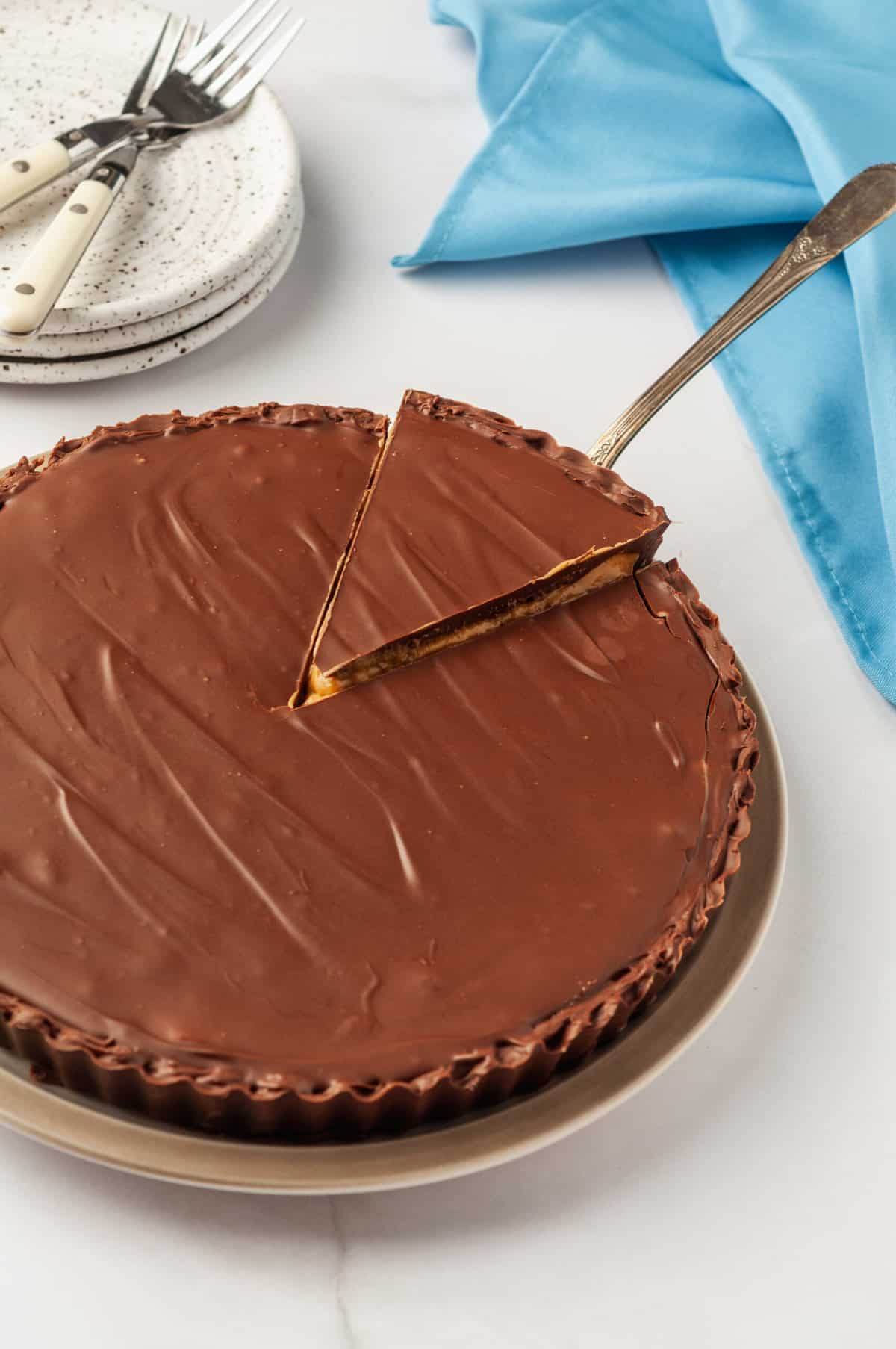 Reese's peanut butter cup pie with a slice getting taken out by a gold cake spatula