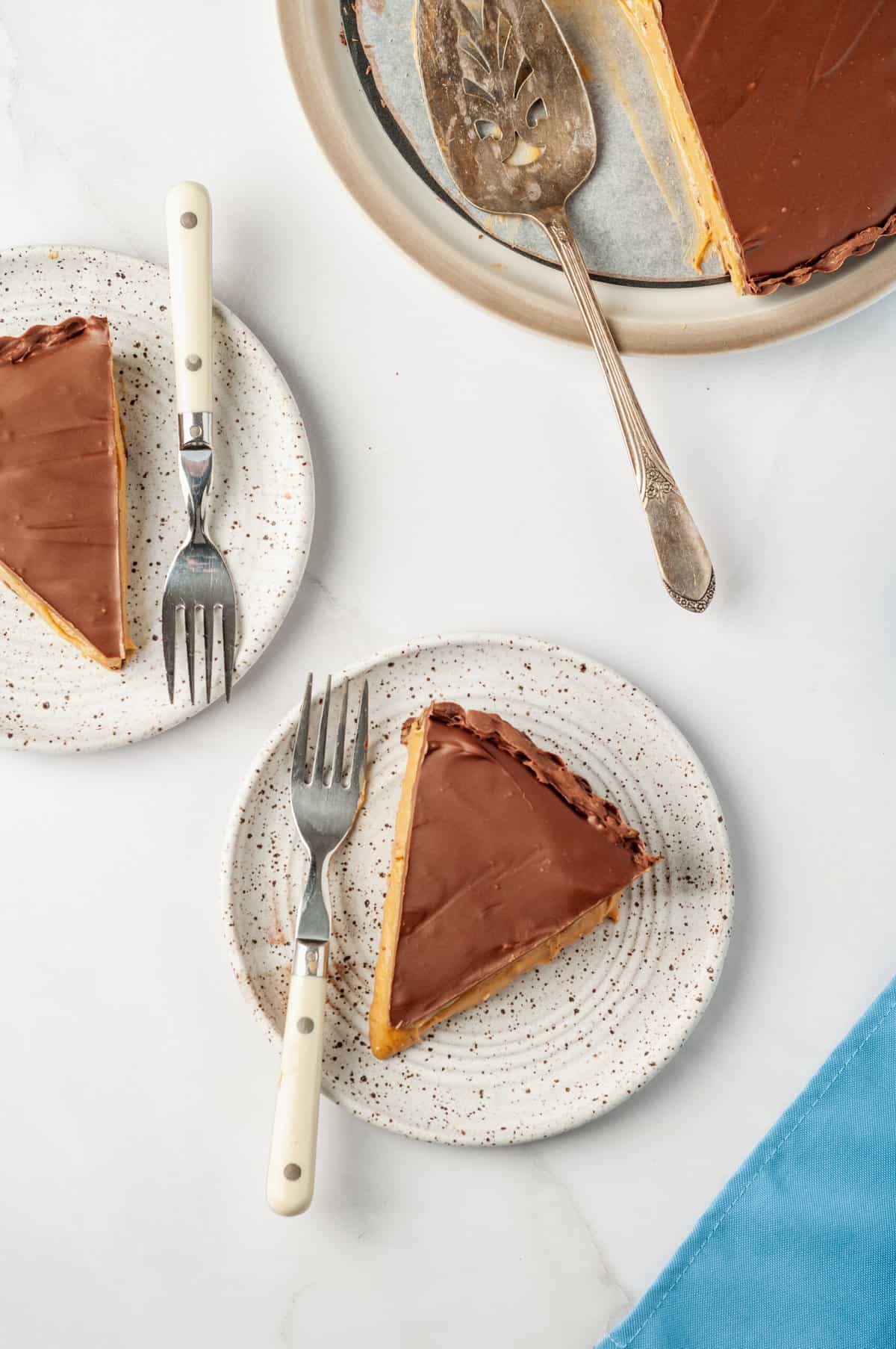 A top down image of servings of peanut butter cup pies served on speckled brown plate with a fork.
