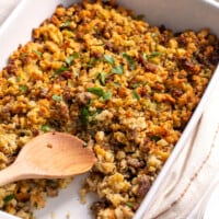 Sausage stuffing in a casserole dish with a portion missing.
